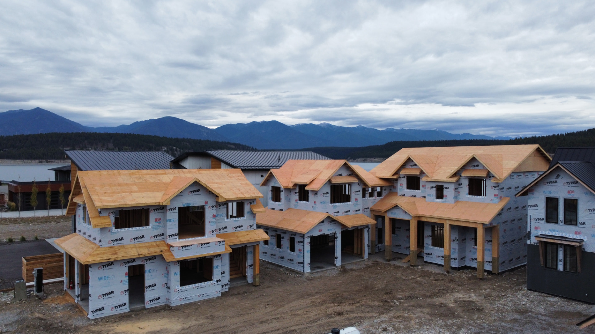 Multiple framed homes against a mountain backdrop